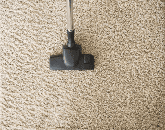 vacuuming tan colored carpet during a deep clean